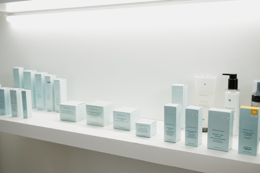 Skincare products displayed on white shelf.