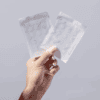 Hand holding clear adhesive patches in packages