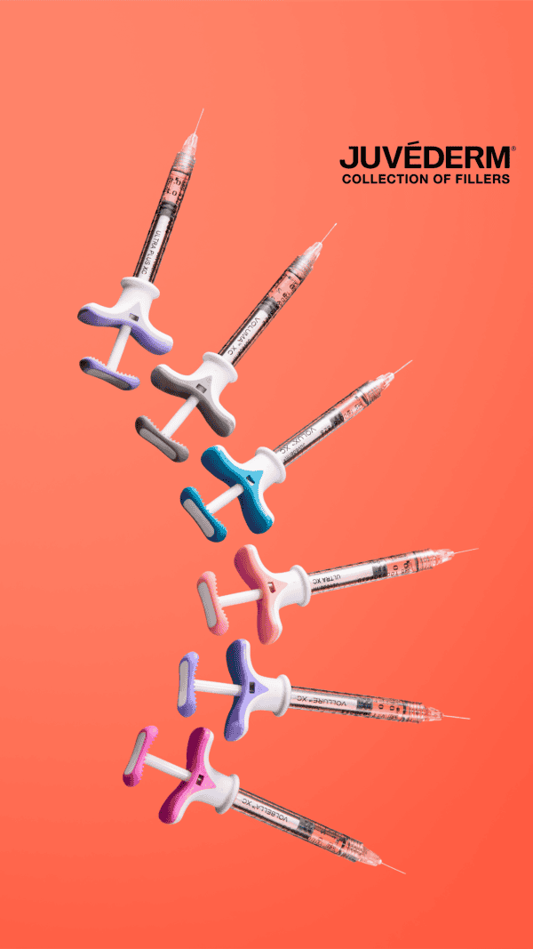 Juvederm dermal filler syringes on coral background