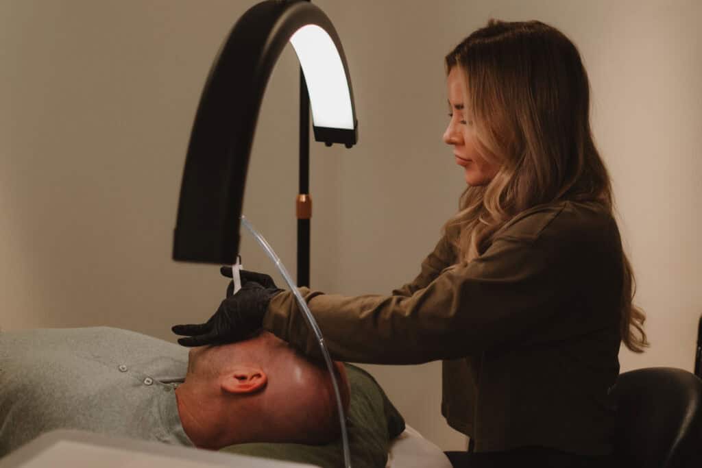 Esthetician performing facial treatment on client