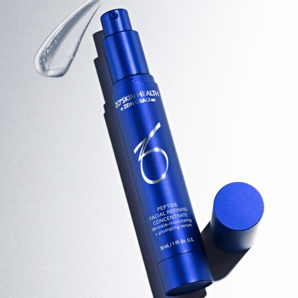 Blue facial serum bottle on gray background